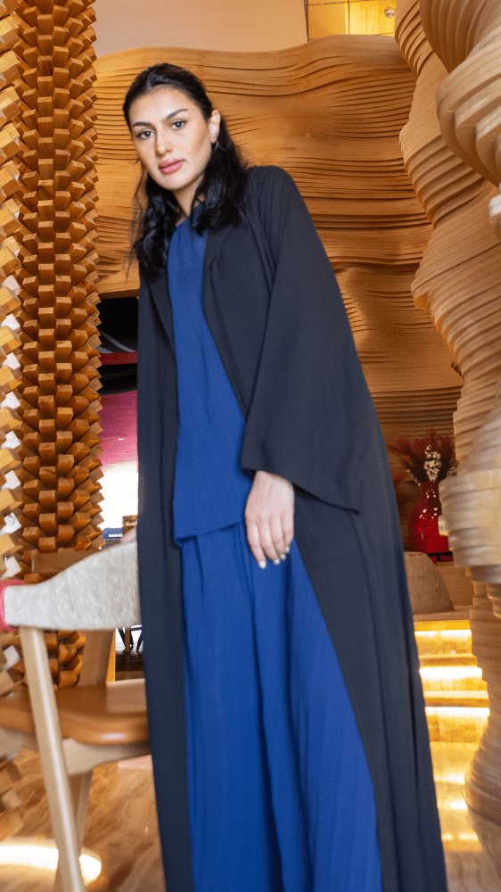 عباية سوداء وطقم بنطلون وبلوزة أزرق