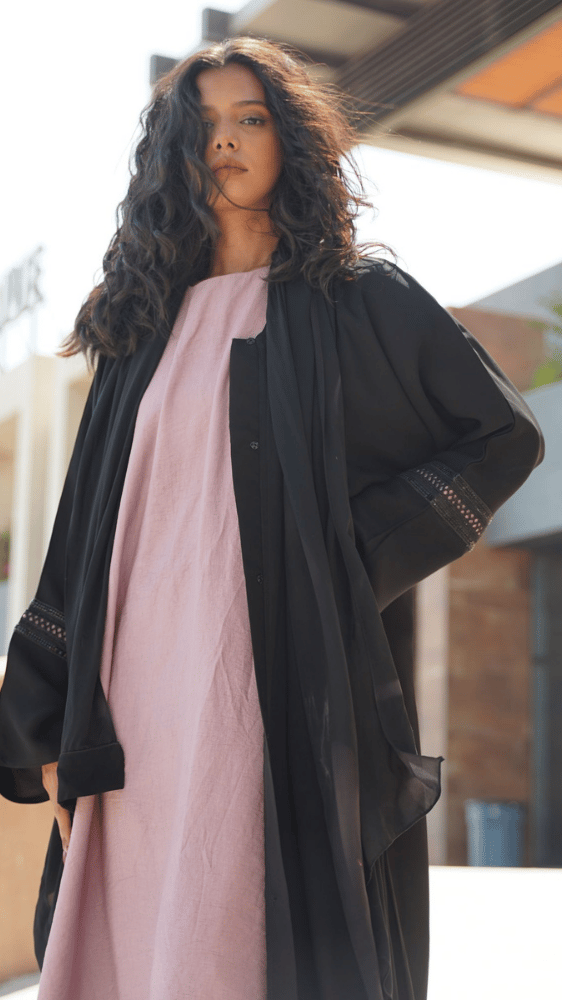 عباية سوداء مع فستان وردي