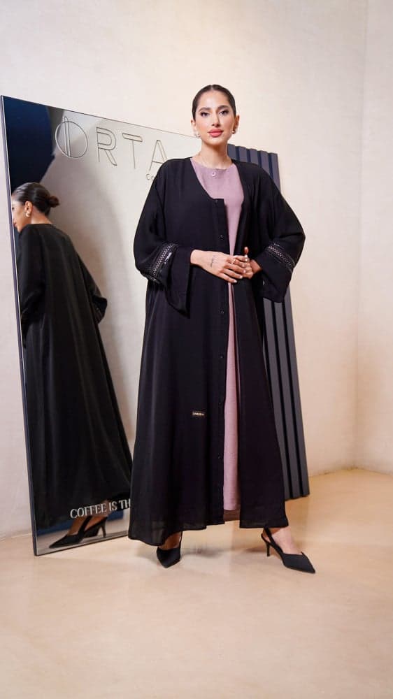 عباية سوداء مع فستان وردي