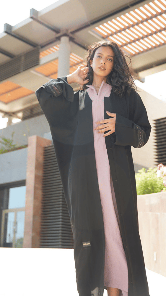 عباية سوداء مع فستان وردي