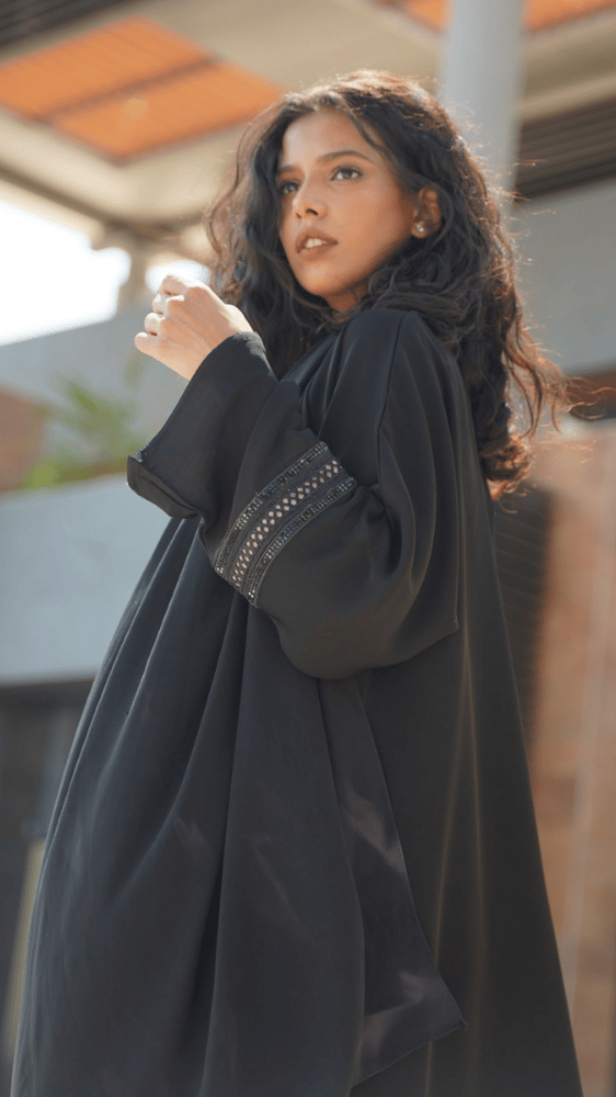 عباية سوداء مع فستان وردي