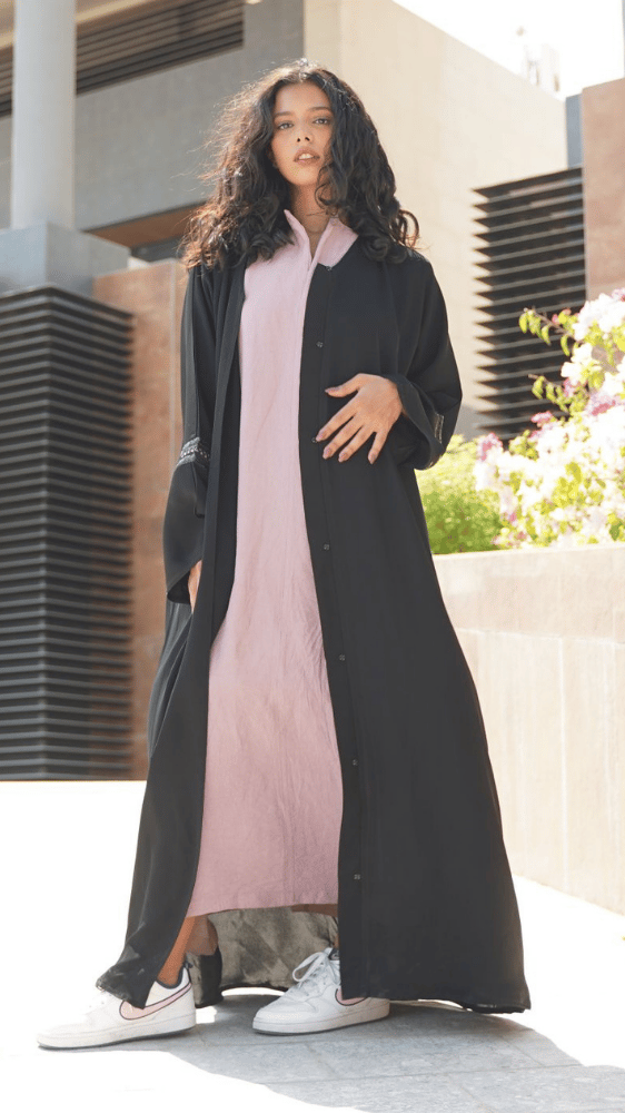 عباية سوداء مع فستان وردي