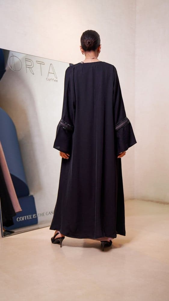 عباية سوداء مع فستان وردي