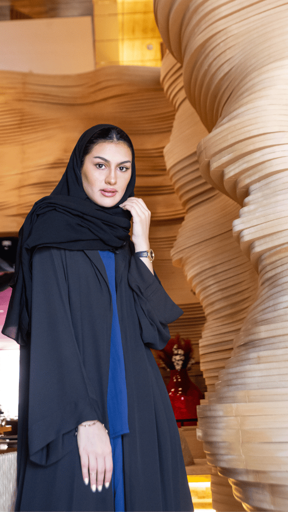 عباية سوداء وطقم بنطلون وبلوزة أزرق