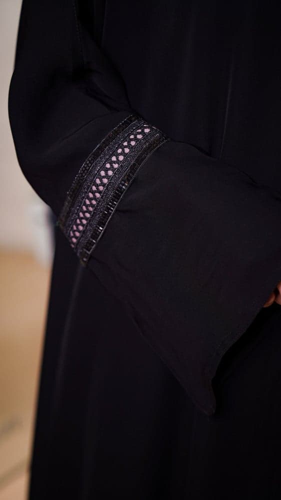 عباية سوداء مع فستان وردي