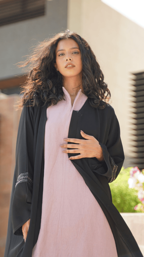 عباية سوداء مع فستان وردي