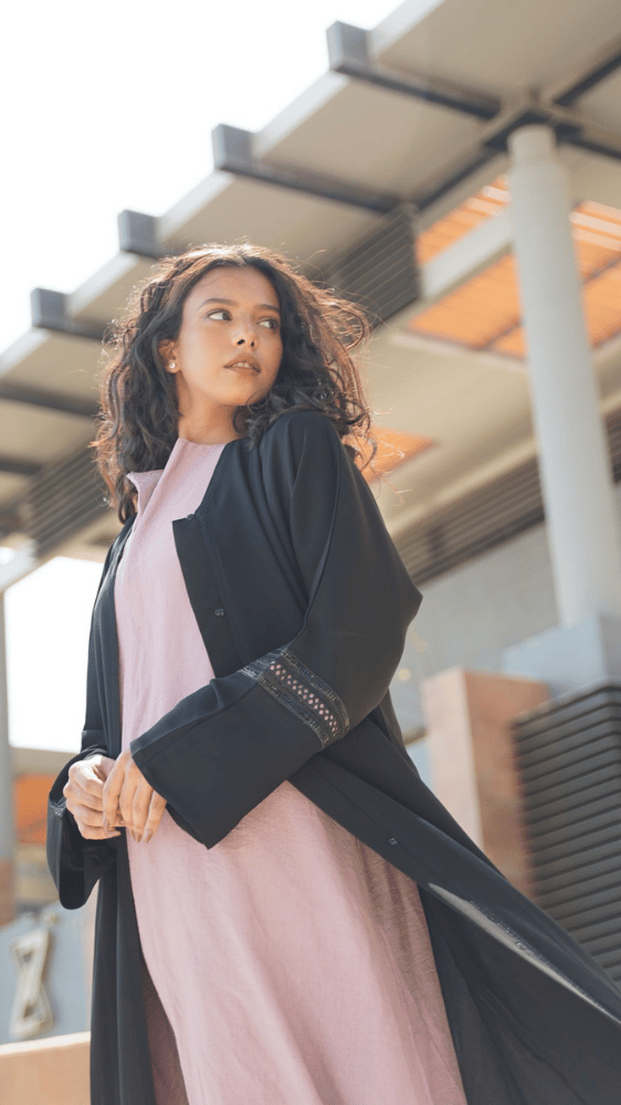 عباية سوداء مع فستان وردي