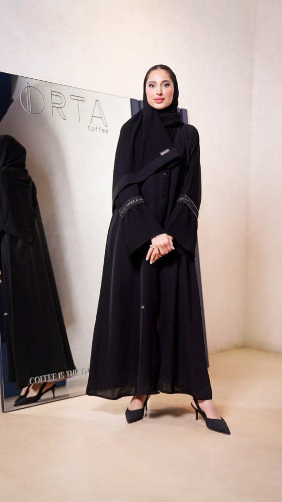 عباية سوداء مع فستان وردي