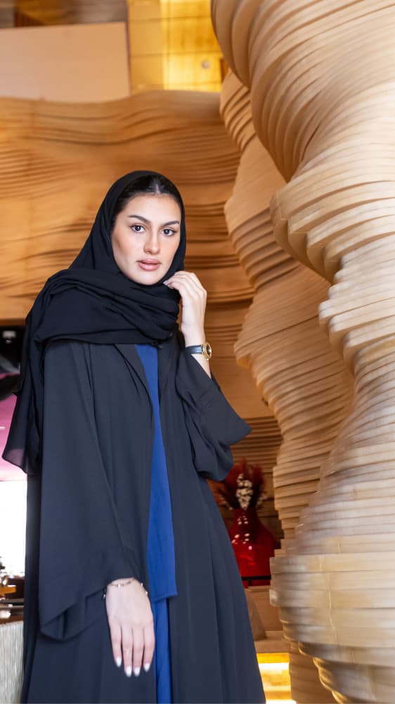 عباية سوداء وطقم بنطلون وبلوزة أزرق